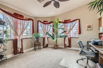 Carpeted office space featuring ceiling fan, visib