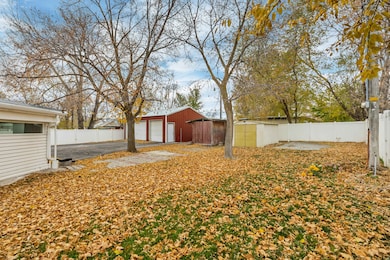 Fenced backyard featuring an outdoor structure, a detached garage, and a patio