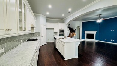 Kitchen featuring stainless steel appliances, open floor plan, a ceiling fan, and dark wood finished floors