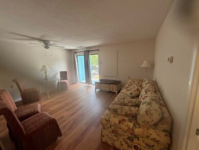 Living room with a textured ceiling, hardwood / wo