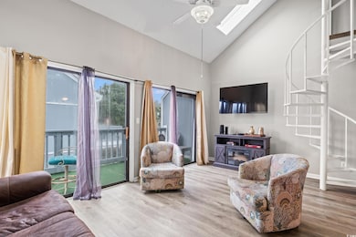 Living room featuring high vaulted ceiling, stairway, wood finished floors, and a ceiling fan