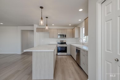 Kitchen featuring stainless steel appliances, light countertops, light brown cabinetry, recessed lighting, and light wood-type flooring