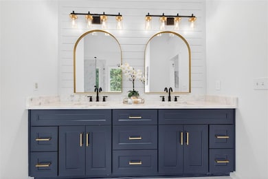 Full bath featuring double vanity and an enclosed shower