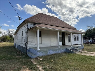 Bungalow-style home with a front yard and covered 