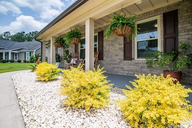 View of exterior entry featuring a porch and brick