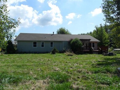 Back of house with deck and trellis