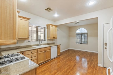 Kitchen with white dishwasher, a sink, light count