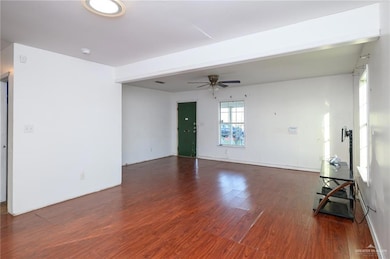 Unfurnished living room with ceiling fan and wood finished floors