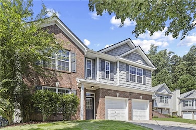 View of front of home featuring brick siding, a garage, driveway, and a front yard