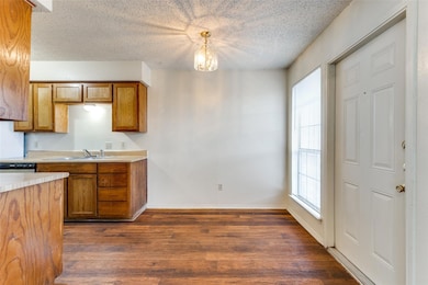 Kitchen featuring light countertops, a sink, brown