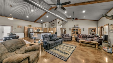Living room with high vaulted ceiling, concrete flooring, french doors, beam ceiling, and recessed lighting