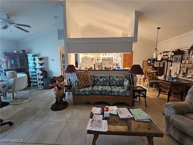 Living room featuring vaulted ceiling, ceiling fan