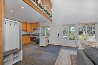 Kitchen with recessed lighting, electric range, open floor plan, under cabinet range hood, and high vaulted ceiling