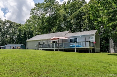 Back of house with a deck, a yard, and view of sca