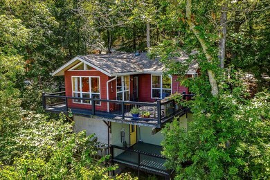 Drone photo showing home in , and just above the trees. Yellow door is  to third bedroom with half bath.