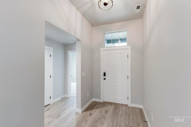 Foyer entrance with light wood-style flooring and baseboards