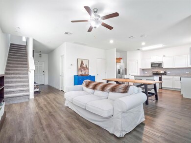 Living room with stairs, ceiling fan, wood finish