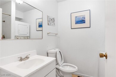 Bathroom with vanity and stacked washer / dryer