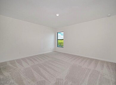 Empty room featuring carpet and a smoke detector