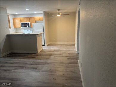 Kitchen featuring white appliances, light wood-sty