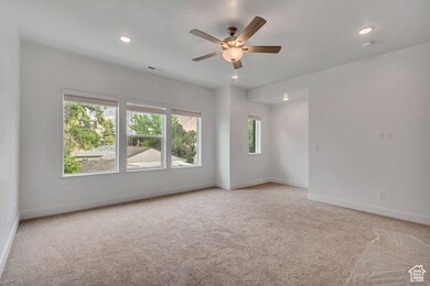 Unfurnished room featuring light carpet, ceiling fan, and recessed lighting