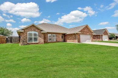 Ranch-style house featuring a shingled roof, a garage, driveway, and brick siding