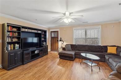 Living room featuring ceiling fan, light wood-type