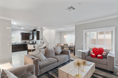 Living room with ornamental molding, light tile pa