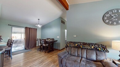 Living area with a chandelier, wood finished floors, beamed ceiling, and high vaulted ceiling