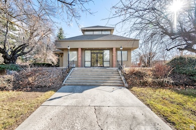 View of front of property with stucco siding, roof with shingles, and covered porch
