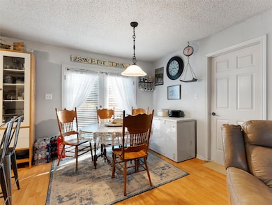 Dining area with a textured ceiling and light hard