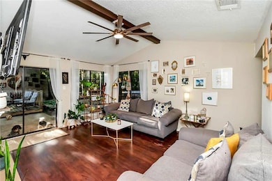 Living area featuring wood finished floors, ceiling fan, and a textured ceiling