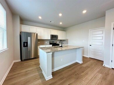 Kitchen with stainless steel appliances, light wo