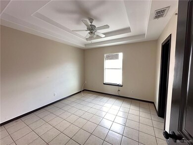 Tiled spare room with a raised ceiling and ceiling fan