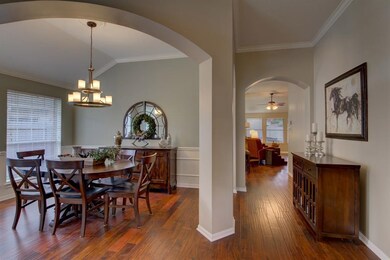 Enter the home with wood flooring and decorative column in the dining room