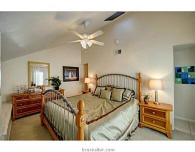 Master Bedroom. This carpeted master bedroom is provided a unique look through the use of a vaulted ceiling and access to the adjoining balcony.