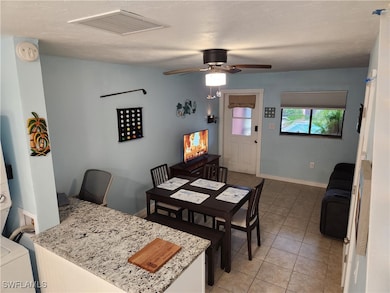 Dining room featuring ceiling fan and light tile p
