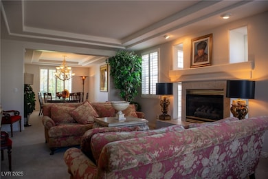 Carpeted living area featuring a tray ceiling, a c