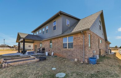 Rear view of house with brick siding, a patio, a f