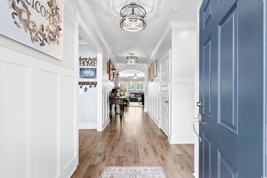 Foyer entrance featuring ornamental molding, light