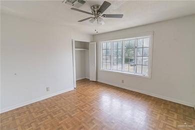 Unfurnished bedroom 1 featuring ceiling fan, light parquet floors, a closet, and a textured ceiling.