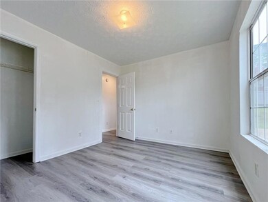 Spare room featuring wood finished floors, baseboards, and a textured ceiling