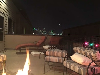 Patio at twilight with a fire pit and a view of city lights
