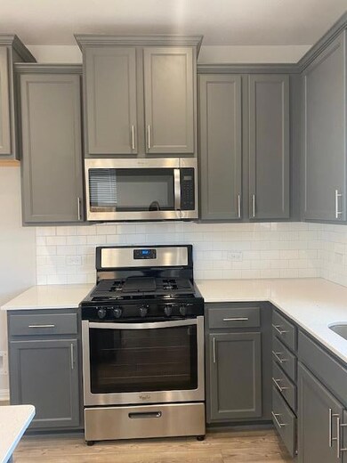 Kitchen with stainless steel microwave, stove, gr