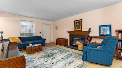 Living area with a fireplace with flush hearth and carpet