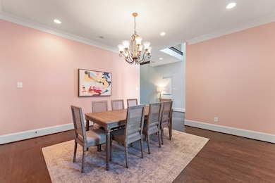 Exquisite formal dining room with crown molding, wood floors, and wine alcove.