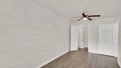 Unfurnished bedroom with wood finished floors and a ceiling fan