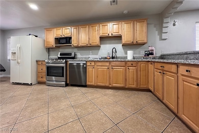 Kitchen with stainless steel appliances, a sink, l