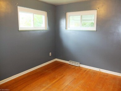Bedroom 2 on main level with wood flooring.