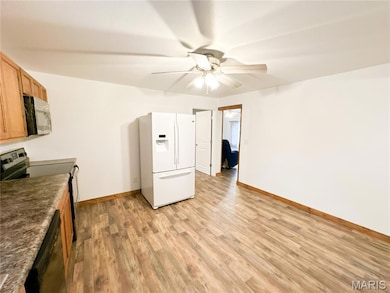 Kitchen with white fridge with ice dispenser, electric range, light wood-style flooring, dark countertops, and dishwashing machine